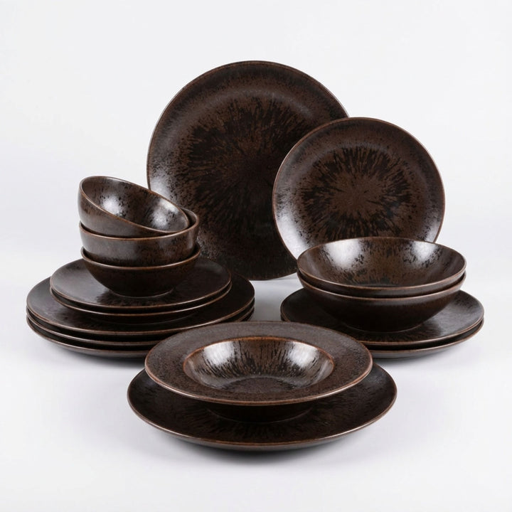 Sebuku Brown ceramic tableware set with plates and bowls in dark earthy tones.