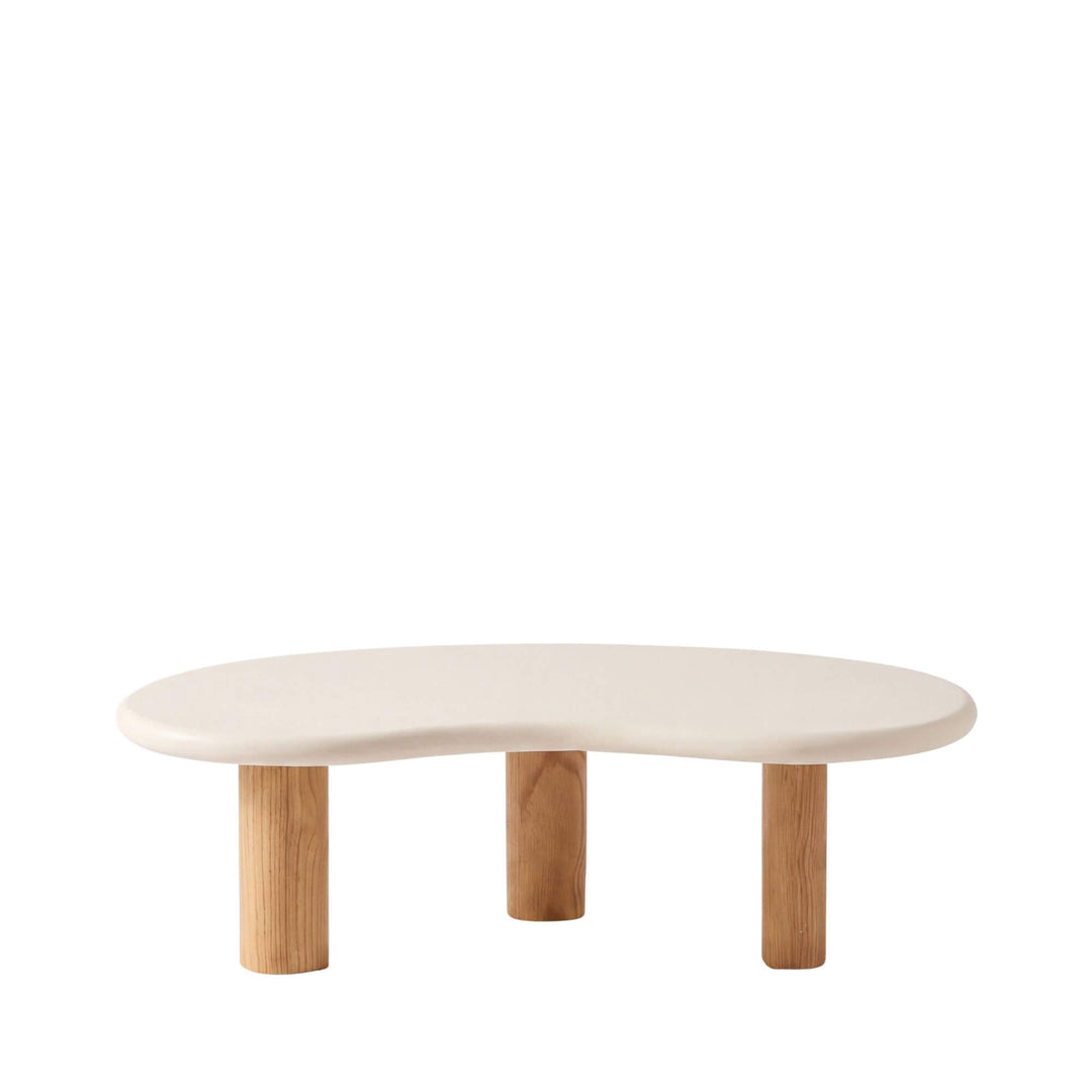 Front view of the Senja coffee table with an organic off-white microcement top and three cylindrical sungkai wood legs