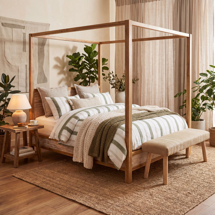 Seychelles teak wood canopy bed styled with neutral bedding in a warm Mediterranean-inspired bedroom
