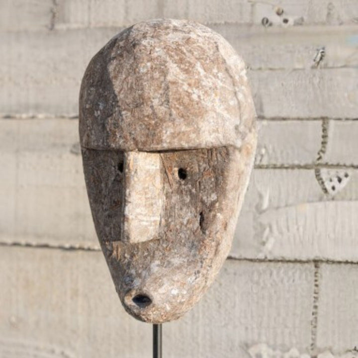 Close-up of the facial details carved into the albasia wood surface.