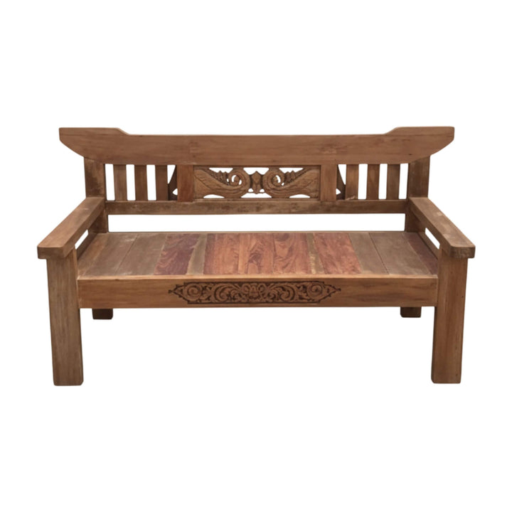 Front view of Skopelos teak wood bench showcasing its carved backrest and wide seating surface.