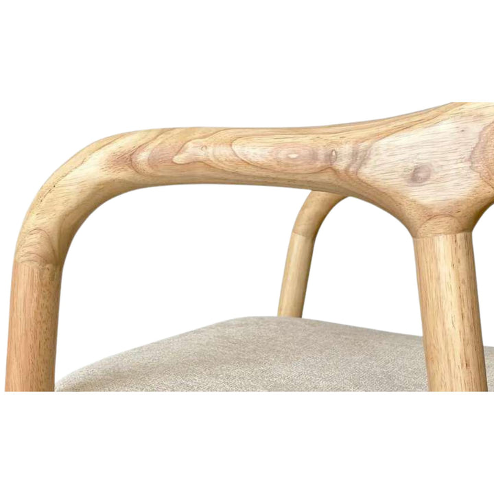 Close-up detail of the curved armrest and chenille seat showing the smooth wood finish and soft upholstery texture.