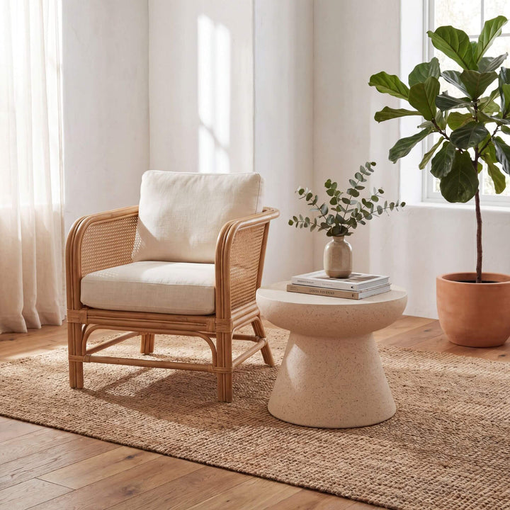 Styled interior setting featuring the stone look side table beside an armchair in a warm natural living space.