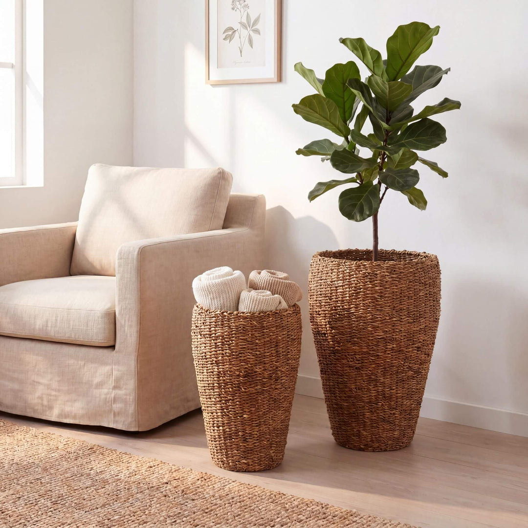 Straw Baskets s with a plant and folded clothes on a light-colored sofa in a room.
