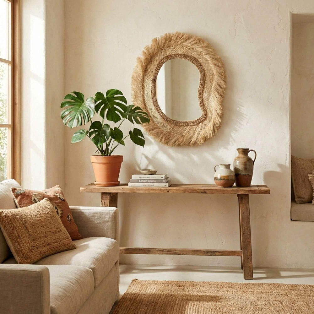 Living room with a beige sofa, wooden console table, and decorative Sulawesi organic mirror.