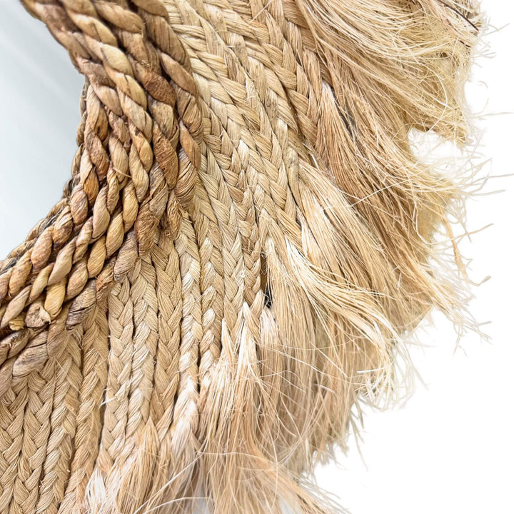 Close-up of Sulawesi Organic Mirror frame in abaca and sisal with textured fringe.