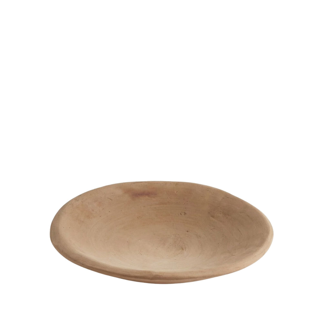 Front view of the Sula terracotta plate with wide shallow shape and natural clay finish.