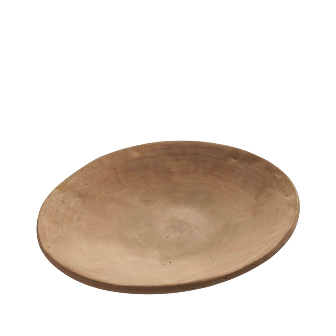 Front view of the Sula terracotta plate with wide shallow shape and natural clay finish.