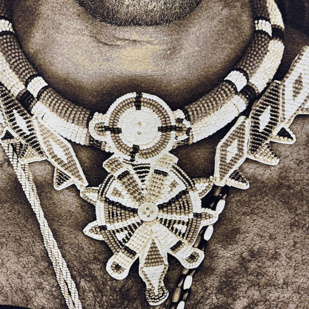 Close-up detail of the Sumburu Man tapestry highlighting the intricate jewelry and textile print texture.