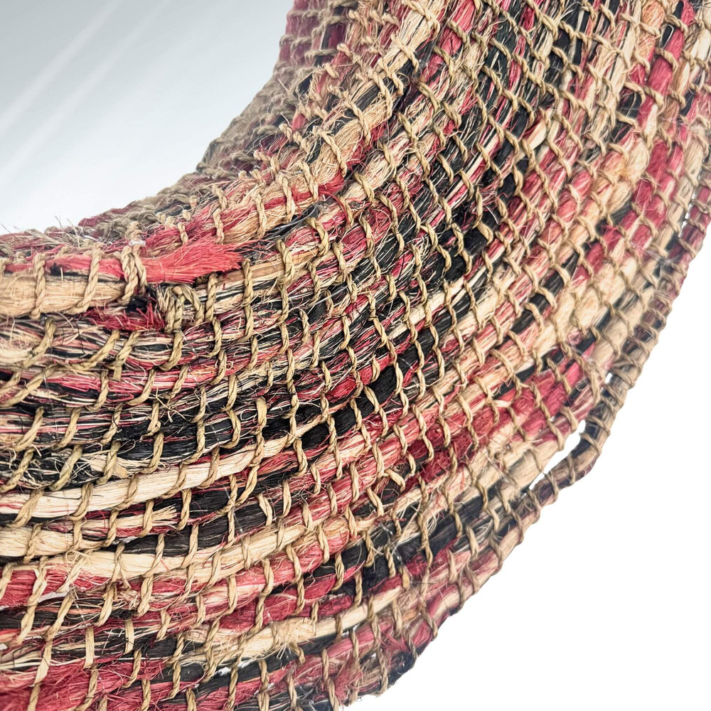 Close-up of Samara Mirror woven frame with natural and red fiber details.