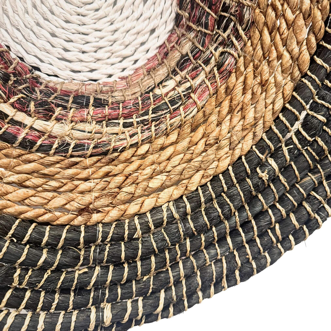 Close-up of Handwoven Sanggar Wall Deco made from abaca, rattan, and cotton in circular natural and black pattern.