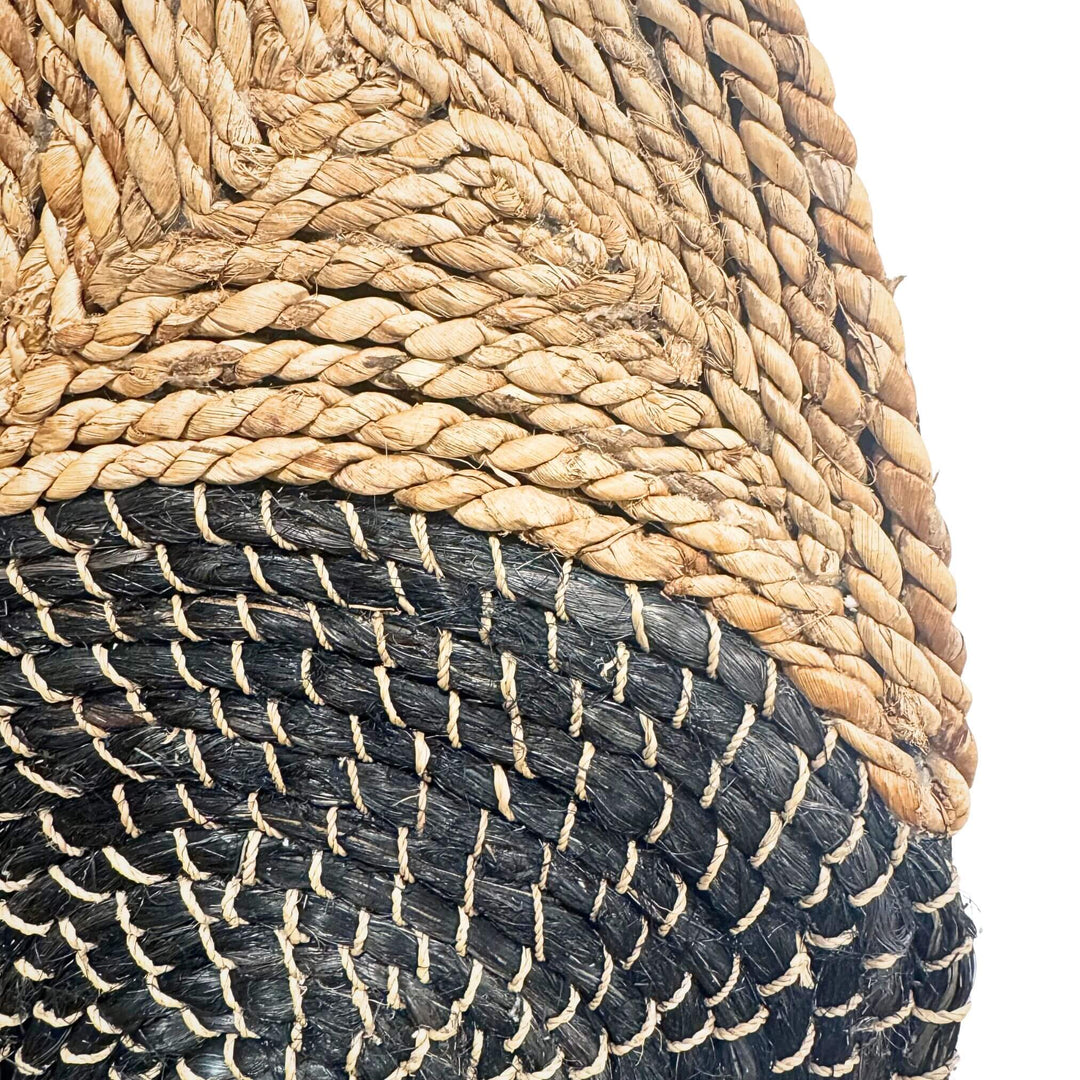 Close-up of Handwoven Sekar Wall Deco made from abaca and rattan in natural and black swirl design.