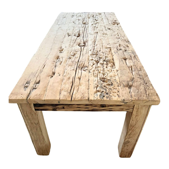 Rustic sleeper wood dining table with weathered surface, angled view