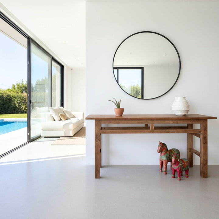 Styled interior featuring the Tamaril console table next to a round mirror.