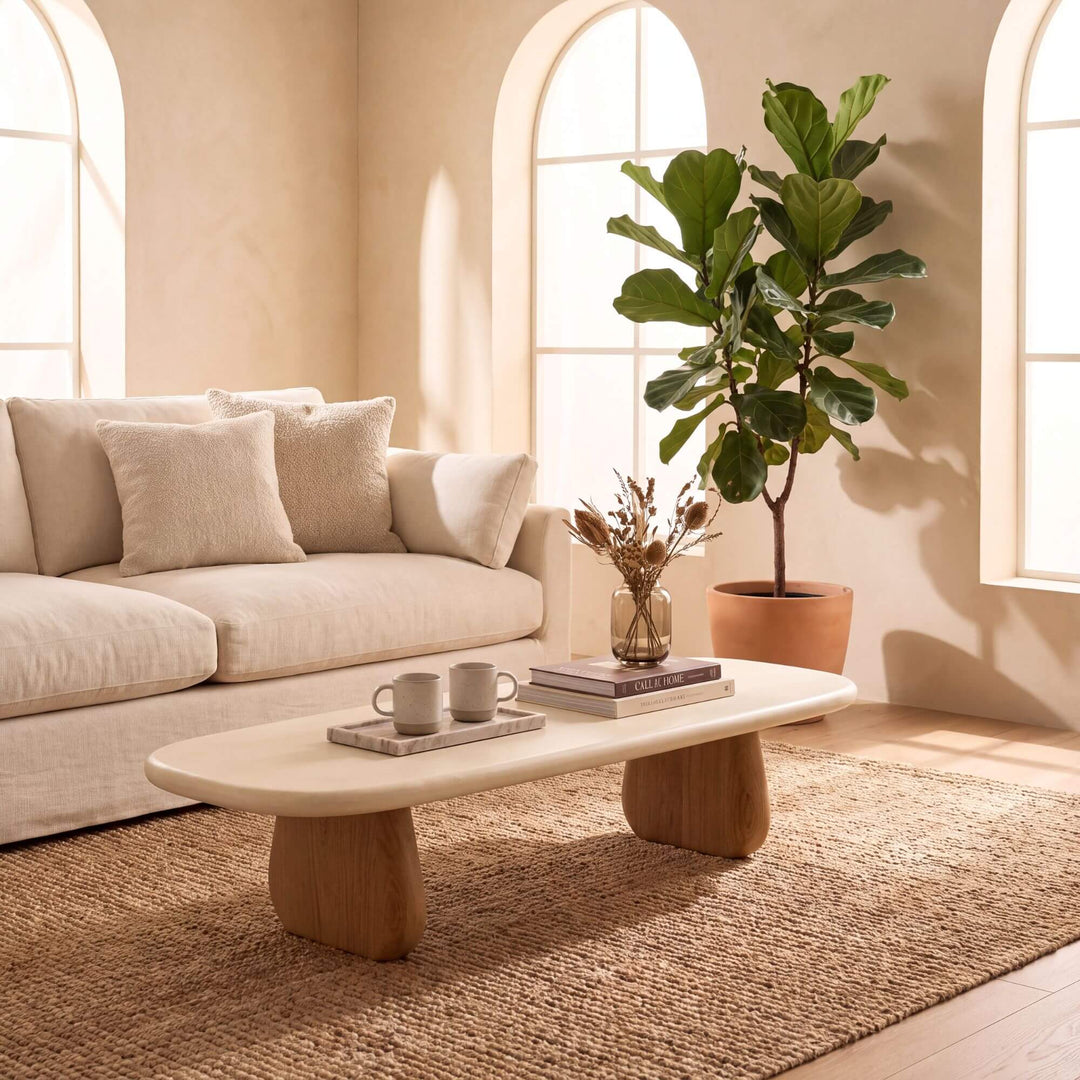 Tao microcement coffee table styled with books and tableware in a warm Mediterranean living room