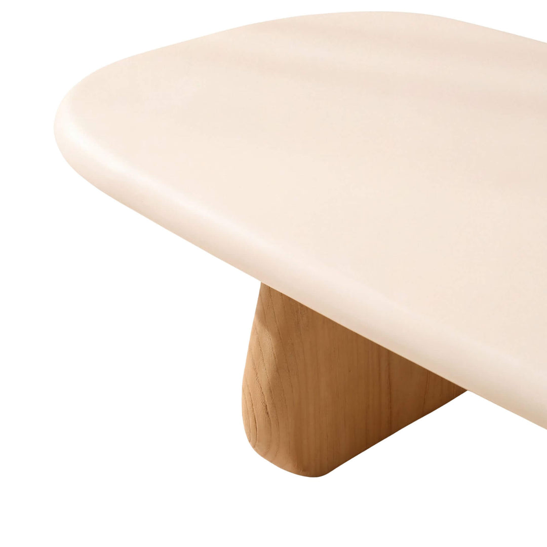 Close-up of the Tao coffee table showing its softly rounded microcement edge and natural sungkai wood support