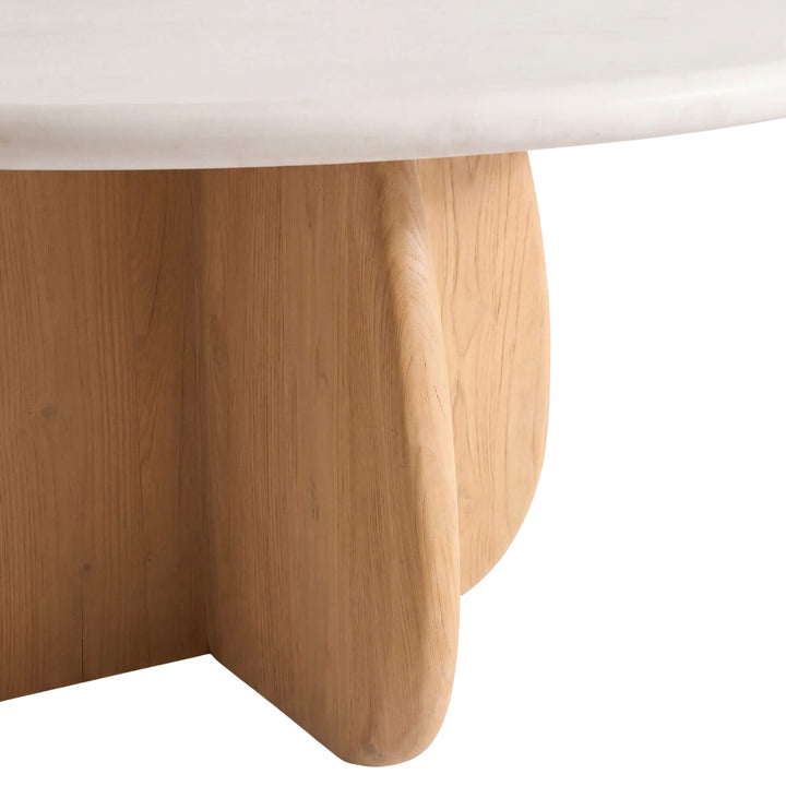 Close-up of the Tao dining table showing its rounded microcement top and intersecting sungkai wood base