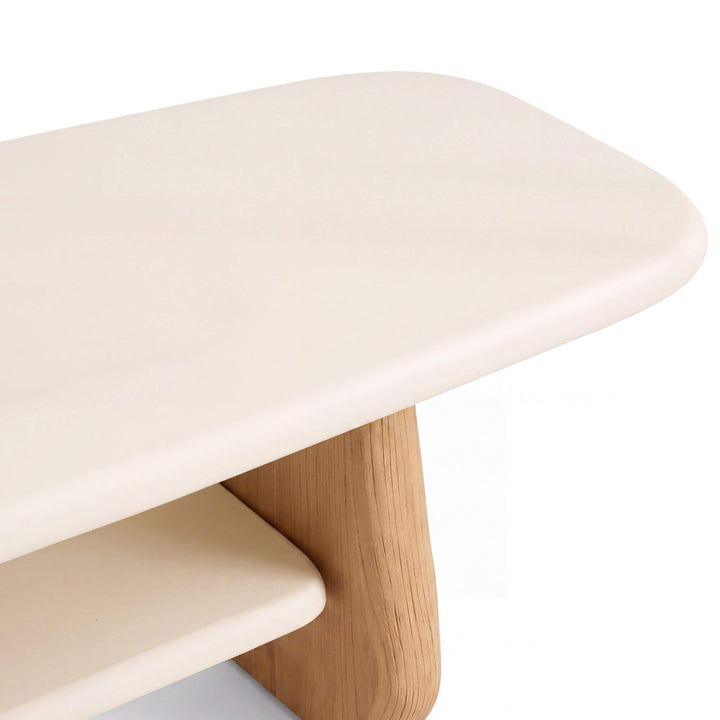 Close-up of the Tao TV console showing the rounded microcement top, lower shelf, and natural sungkai wood support