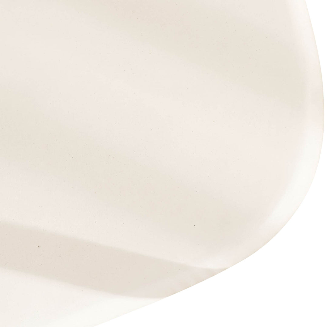 Close-up of the Tao TV console showing its softly rounded microcement edge and smooth mineral finish