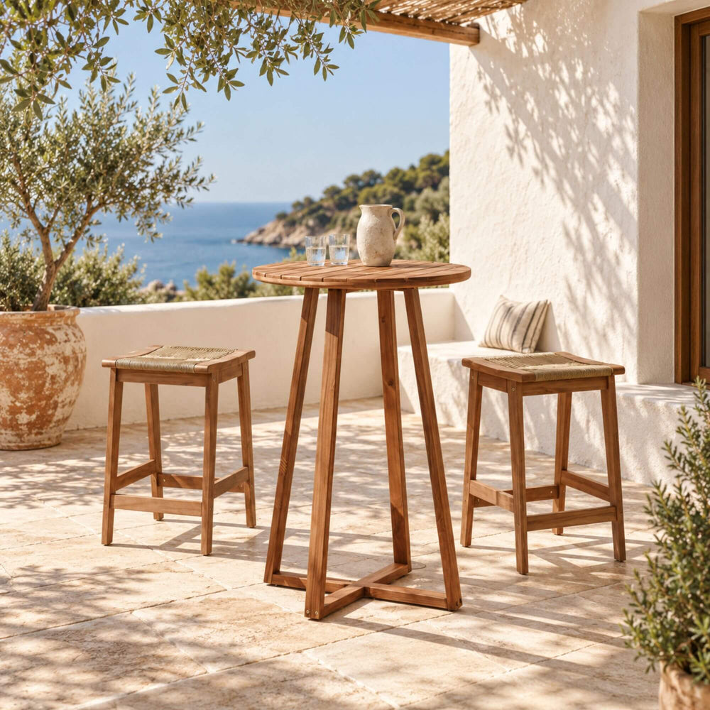 Tavira acacia wood bar table styled with stools on a warm Mediterranean-inspired covered terrace