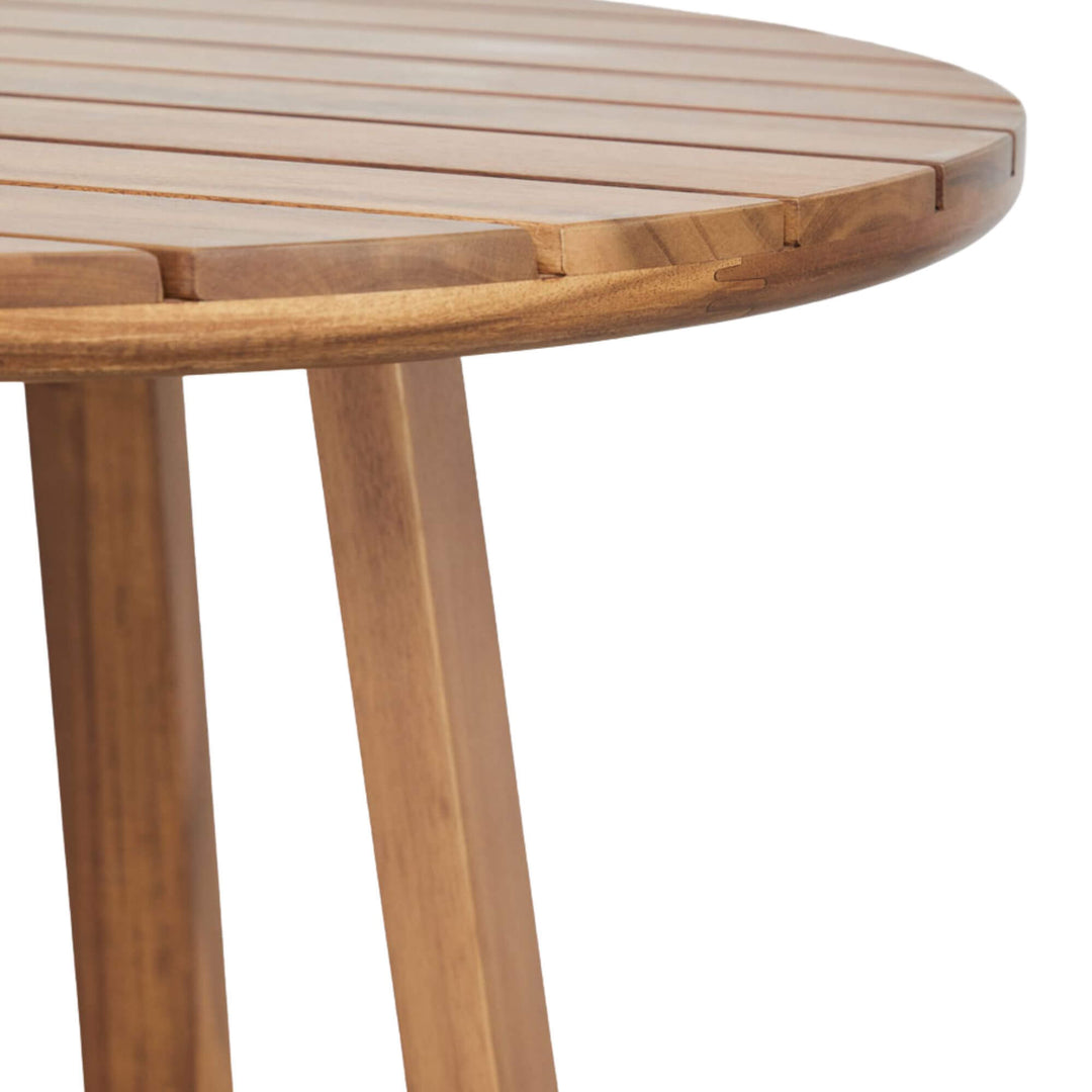 Close-up of the Tavira bar table highlighting the round slatted acacia wood top and natural wood structure