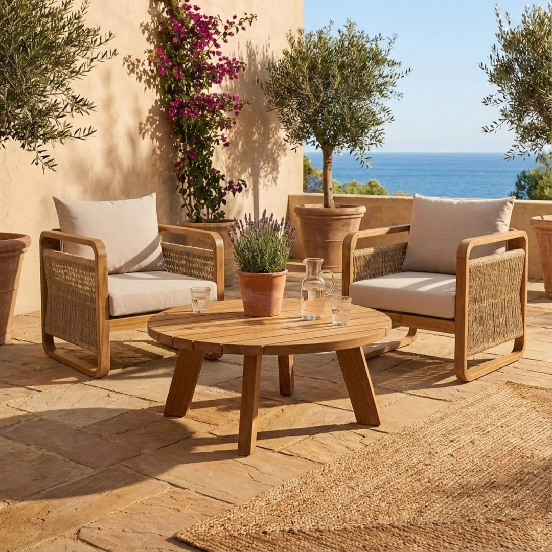 Outdoor setting featuring the round teak coffee table styled with garden seating.