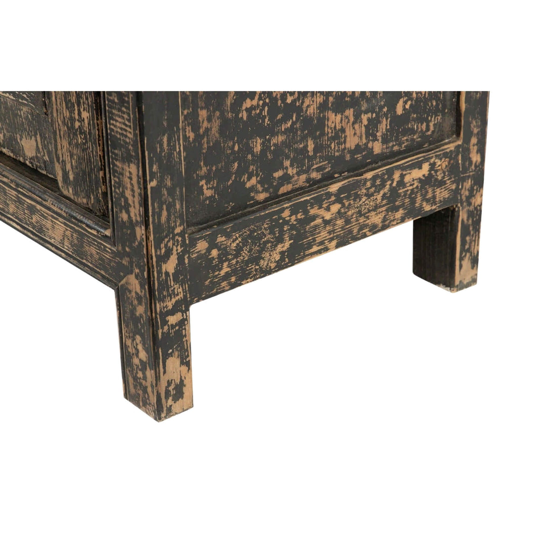 Close-up of distressed black finish on teak wood leg and frame