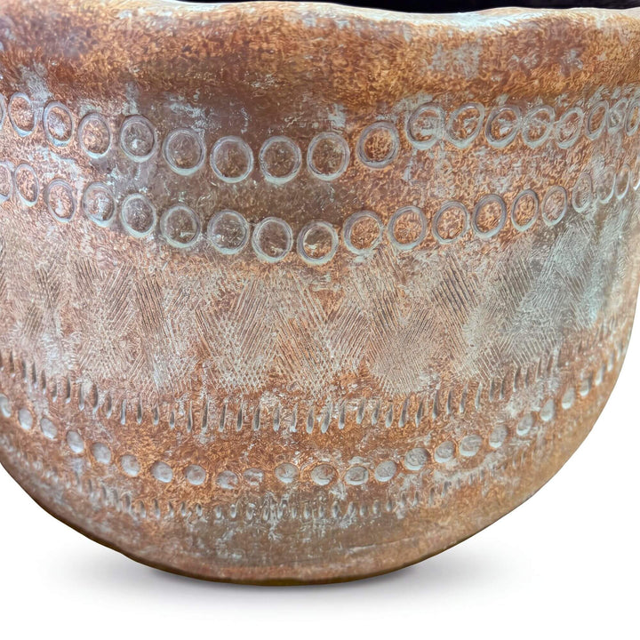 Close-up detail of the planter surface showing the weathered finish and decorative pattern.