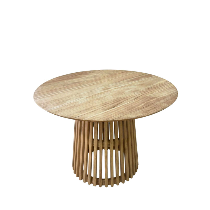 Front view of the Thai dining table showing its round sungkai wood top and sculptural slatted pedestal base.