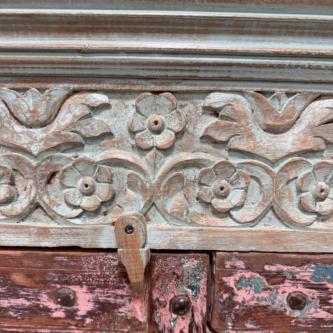 Close-up of the carved floral details on the turquoise Thoha Buffet.
