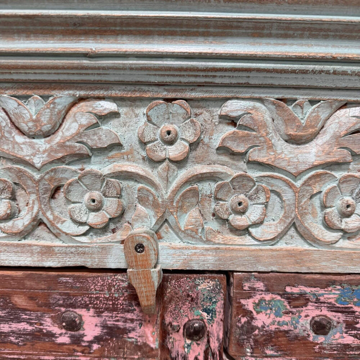 Close-up of the carved floral details on the turquoise Thoha Buffet.