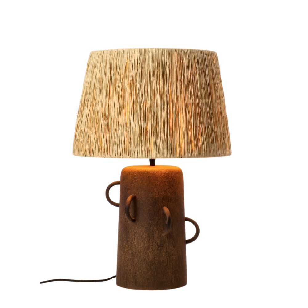 Tikal lamp illuminated, showing warm glow through the jute shade.