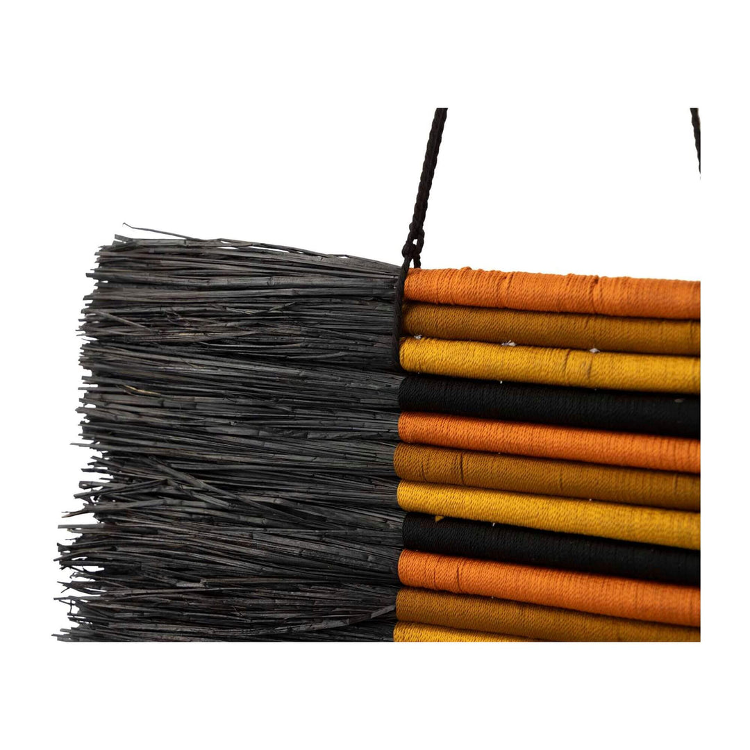 Close-up of handcrafted natural fiber wall decor with layered textures and earthy colors.