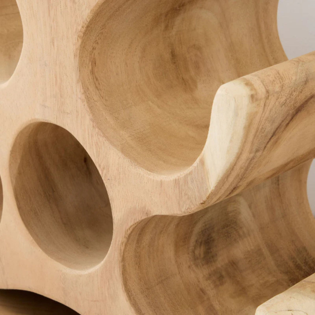 Close-up detail of the smooth curves and natural wood grain of the Trembesi wine rack.