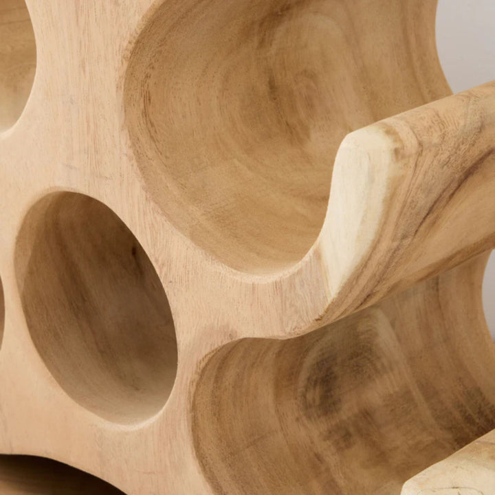 Close-up detail of the smooth curves and natural wood grain of the Trembesi wine rack.