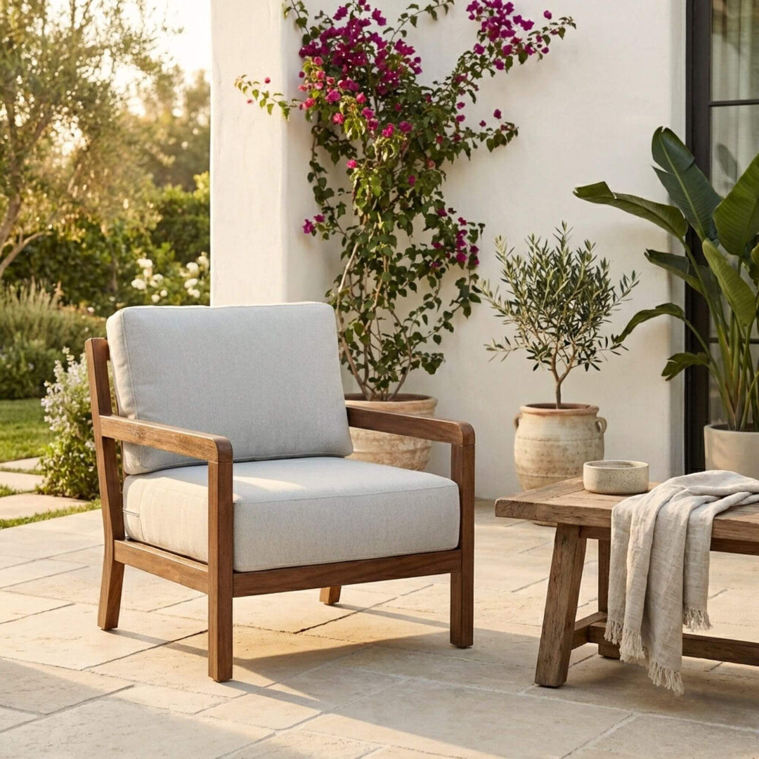 Front view of the Tropika outdoor armchair showing its iroko wood frame and cushioned seat.