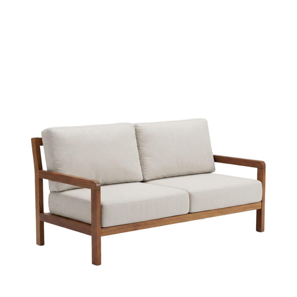 Angled view of the Tropika outdoor sofa showcasing its iroko wood frame and neutral cushions.