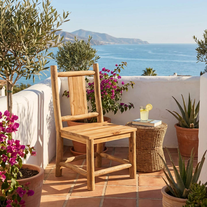 Styled outdoor dining setting featuring the Tupai chair on a terrace with Mediterranean views.