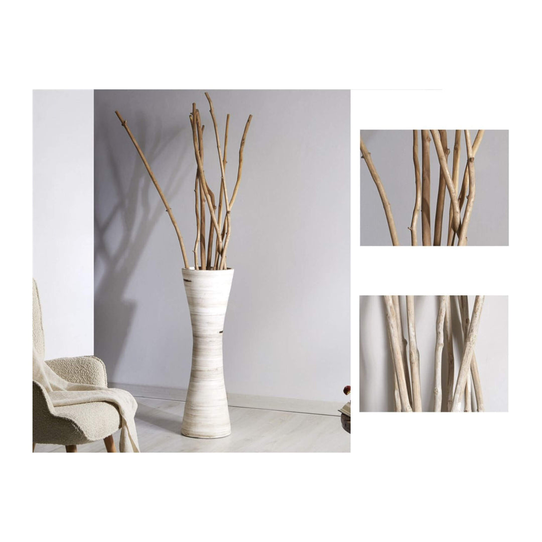 Tall whitewashed teak wood branches arranged in a decorative floor vase in a modern interior.