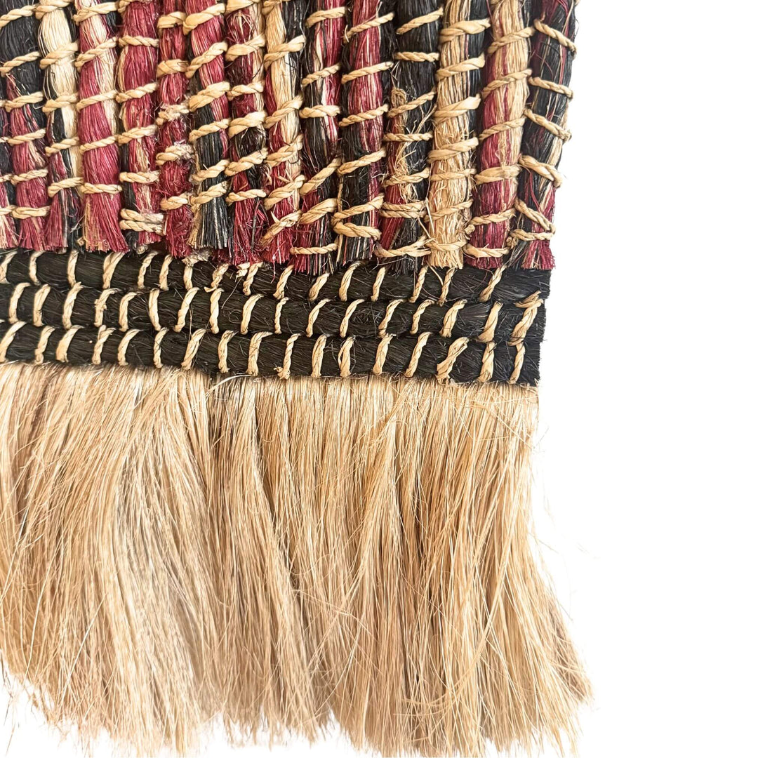 Close-up of Teguh Wall Deco handwoven from abaca, cotton, and rattan with arch design and natural fringe