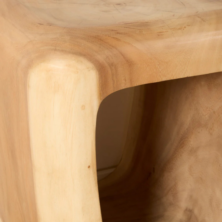 “Close-up of Trembesi Bedside Table showing natural wood grain and smooth curved edges.”
