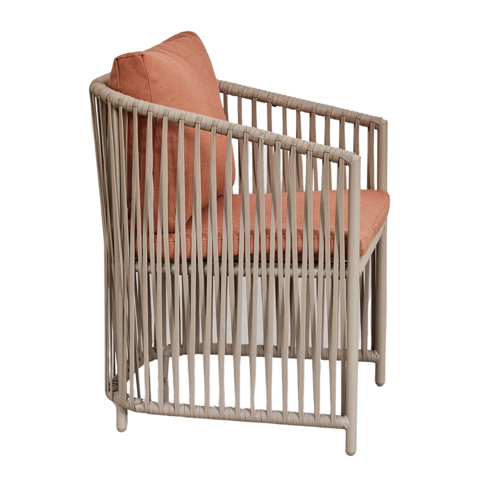 Side angle of Ubud dining chair with aluminum frame and salmon cushion.