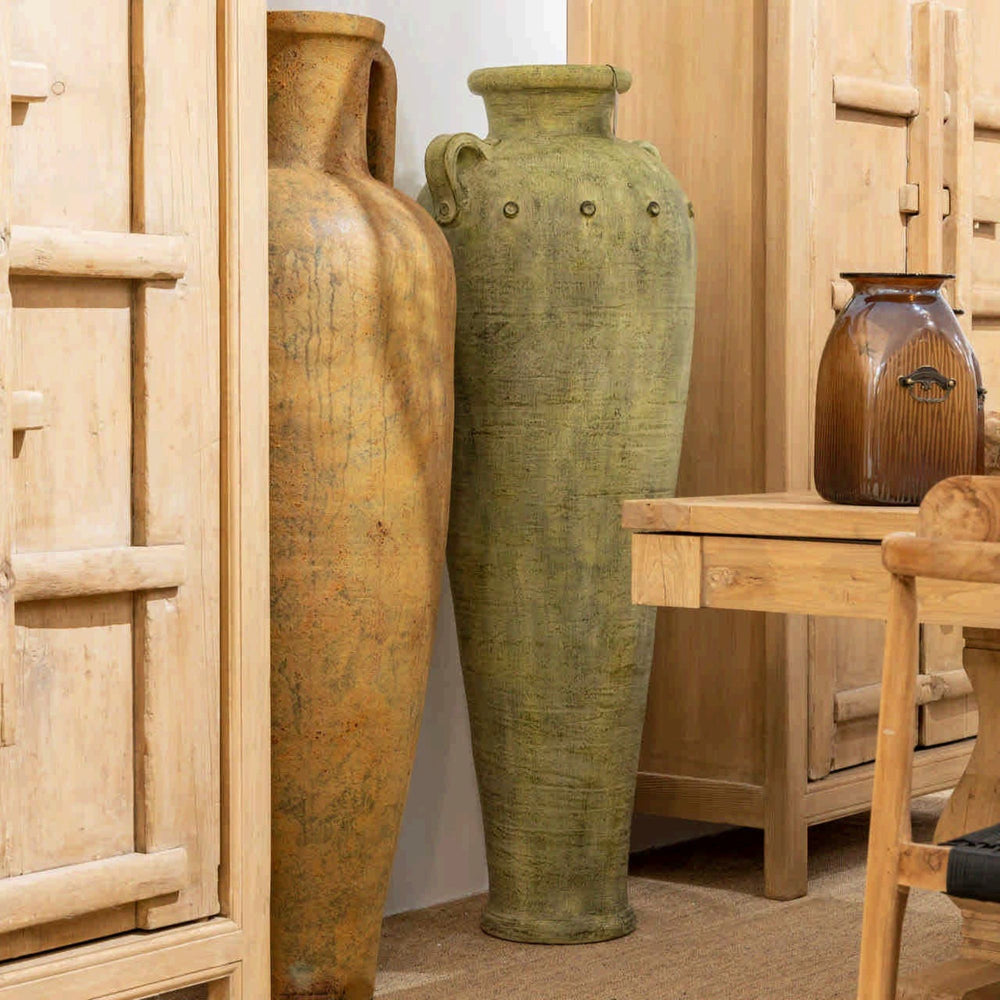 Styled interior setting featuring the Ulua vase among rustic ceramic vessels.