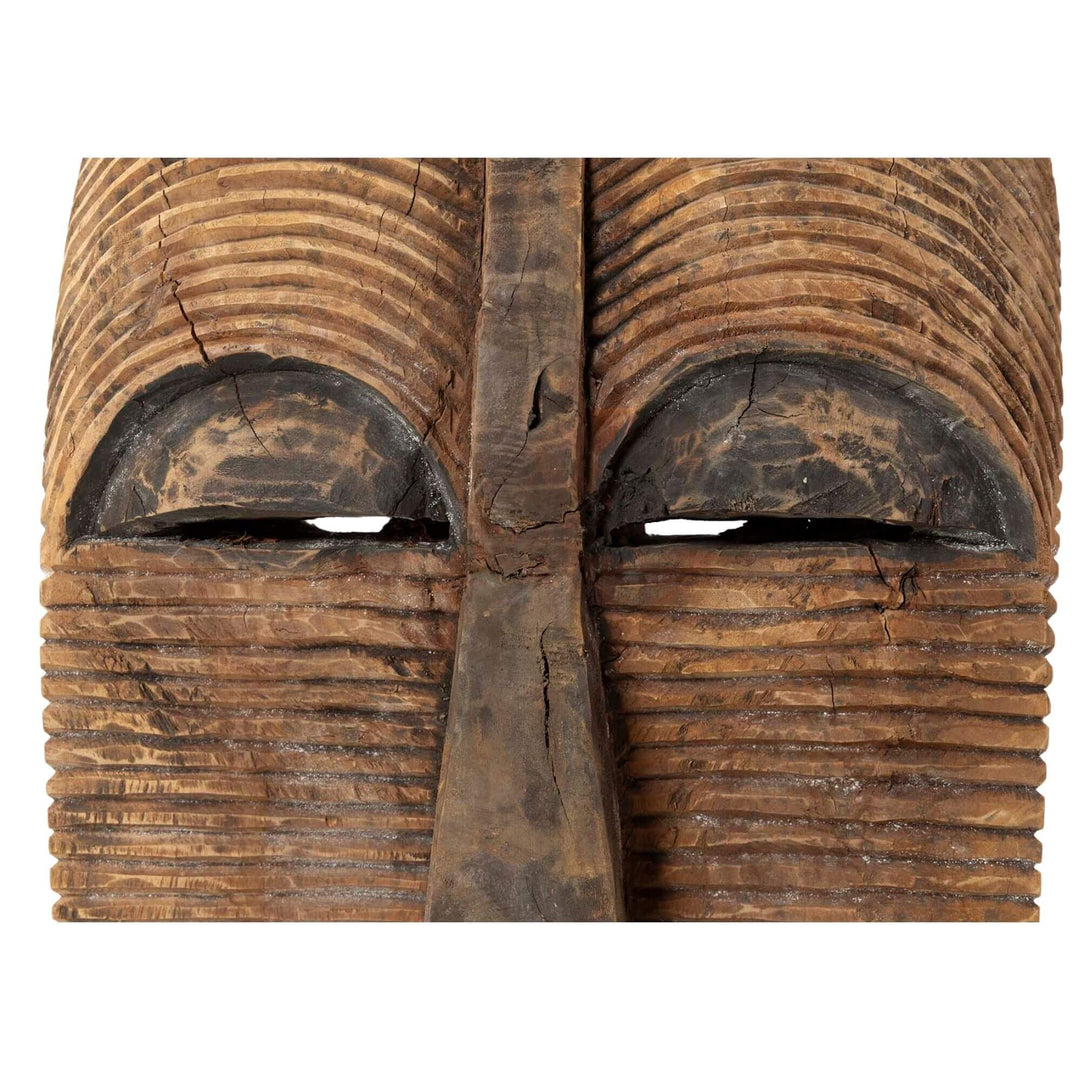 Close-up of Unkulunkulu sculpture showing facial carving and wood texture.