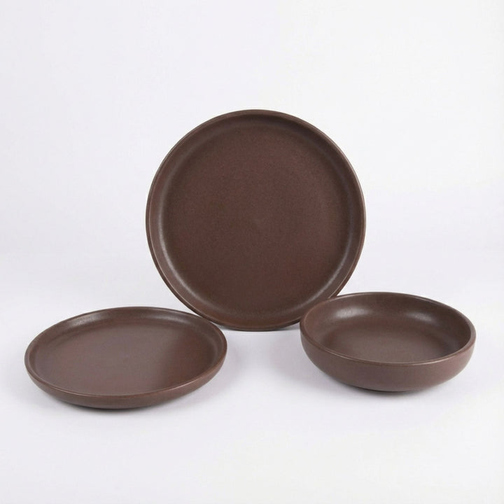 Set of Uno Choco ceramic tableware in chocolate brown displayed on a white background.