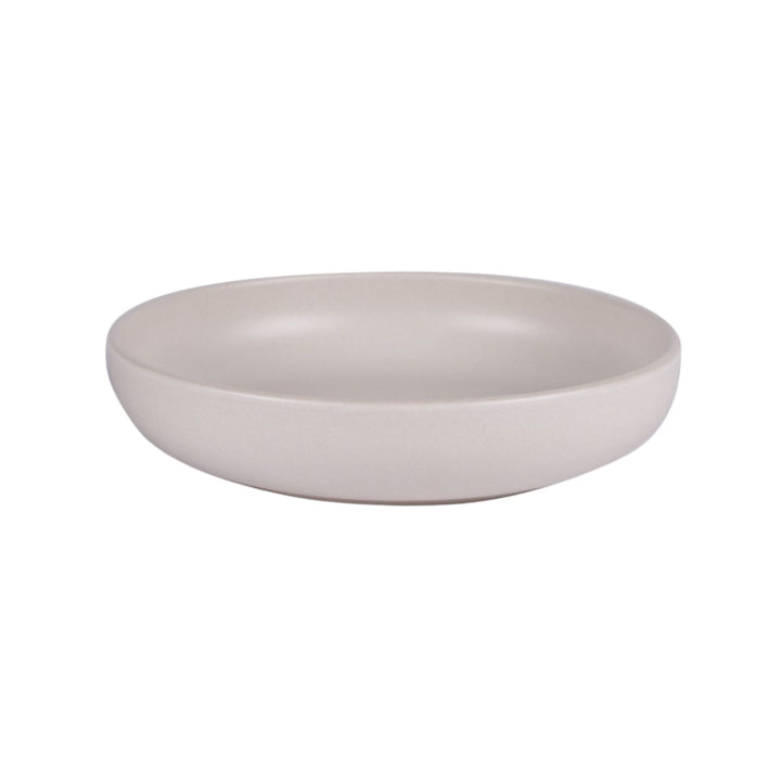 Side view of Uno Cream ceramic bowl highlighting its shallow profile and smooth texture.