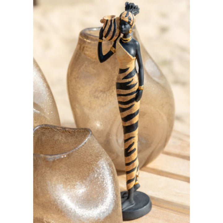 Decorative statue Val girl deco of a woman with zebra-patterned dress and headpiece, standing next to a textured vase.