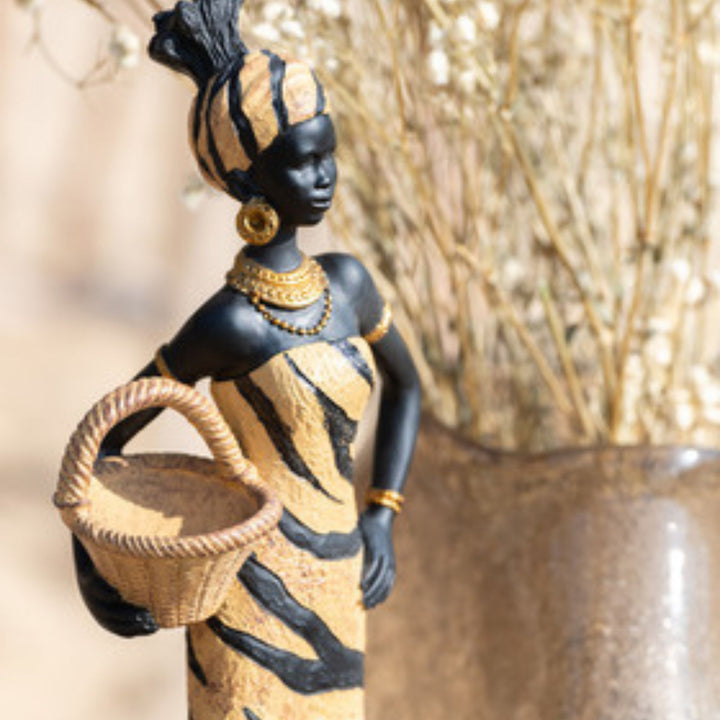 Decorative figurine of a woman holding a basket with gold and black details.