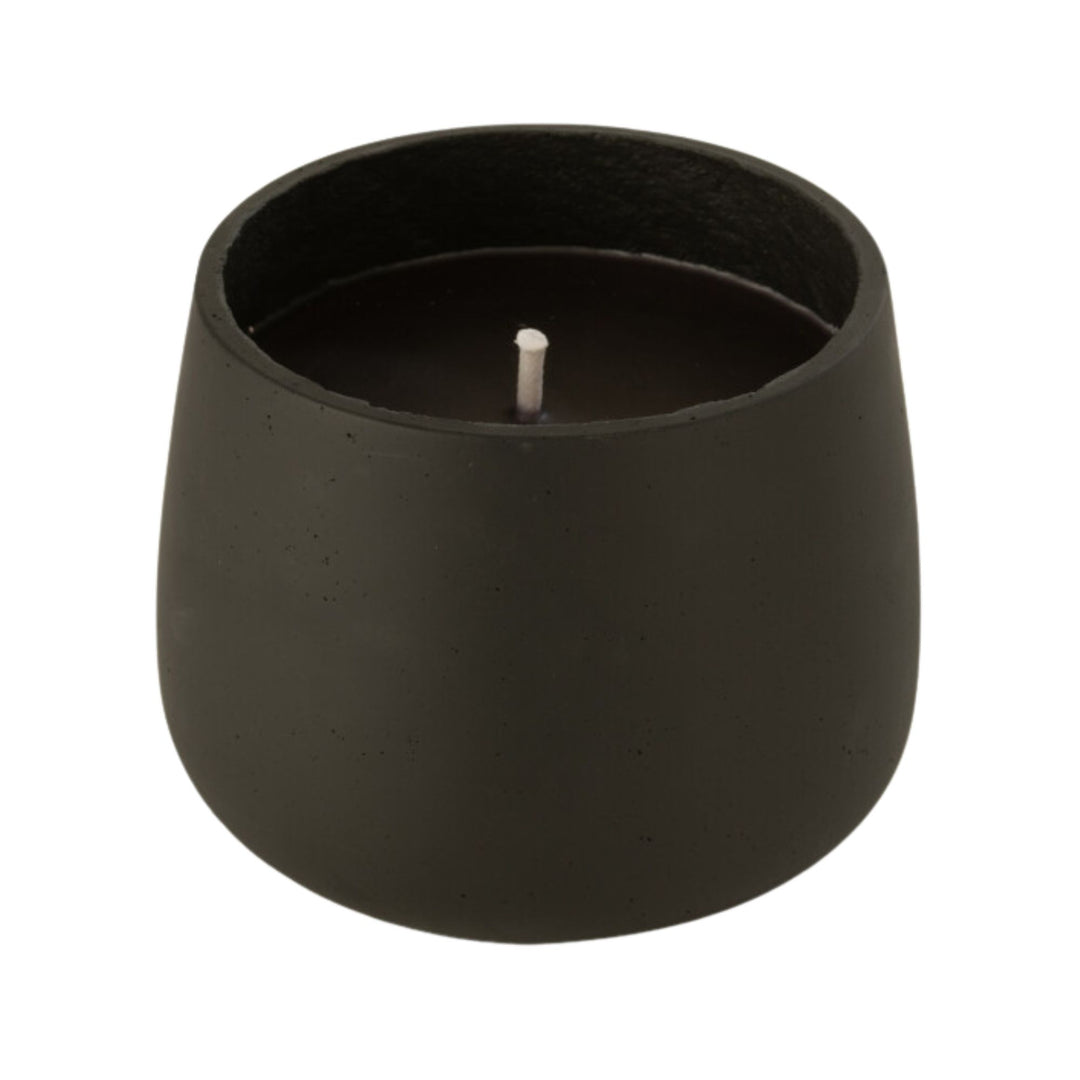 Front view of the Vamizi Black Candle in a matte black cement container.