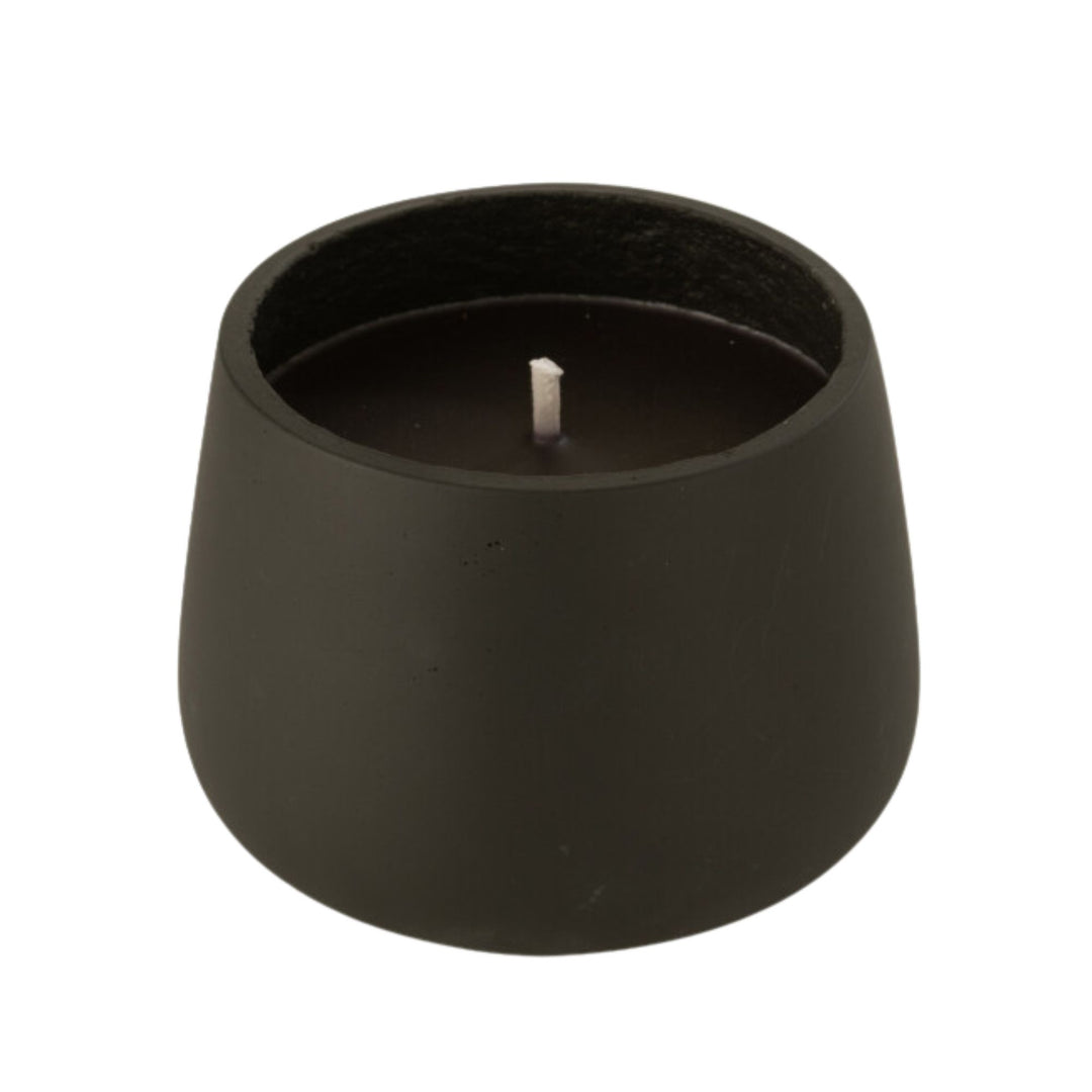 Front view of the Vamizi Black Candle in a matte black cement container.